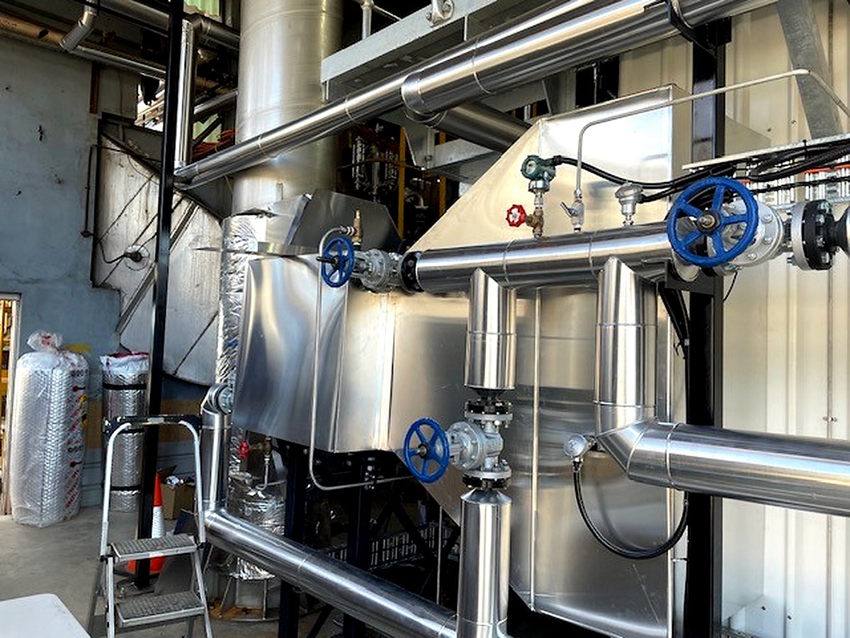 Sheet metal cladding being installed on an industrial process vessel during commissioning